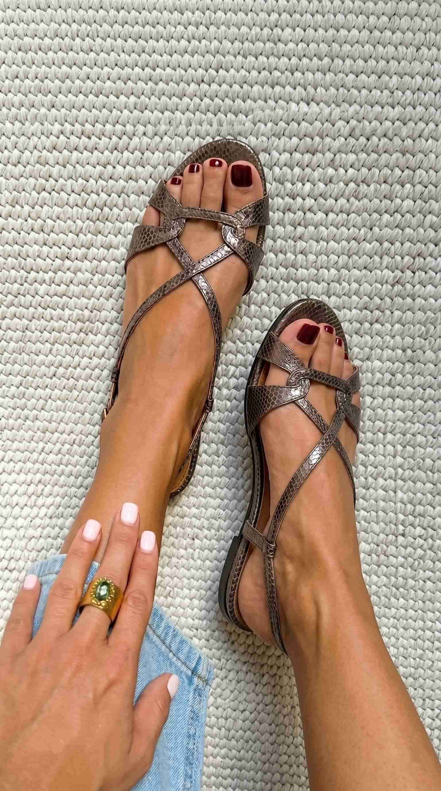 Sandalias planas destalonadas de color bronce, con puntera abierta y efecto piel de serpiente.